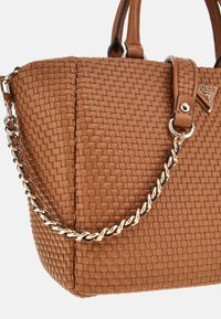 Borsa a tracolla sintetica intrecciata marrone con doppio manico, strap removibile a catena e una placca con logo in metallo. Superficie testurizzata e forma strutturata.