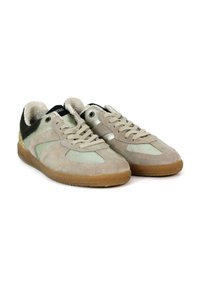 Zapatillas de ante en beige con detalles en verde, paneles texturizados, un talón negro y una suela de goma. Cuentan con cierre de cordones y detalles metálicos.