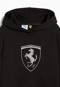 Felpa nera con cappuccio caratterizzata da un prominente logo Ferrari argentato e dall'emblema del cavallino rampante su uno sfondo a scudo. Tessuto morbido con cappuccio.