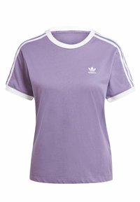 Lila bomull t-shirt med vit ribbad krage och ärmslut. Har tre vita ränder längs varje axel och en liten logotyp på bröstet.