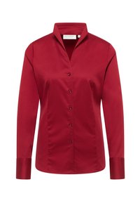 Camicia rossa con colletto a V, maniche lunghe, texture liscia e leggero lucido. Presenta bottoni abbinati lungo la parte anteriore.
