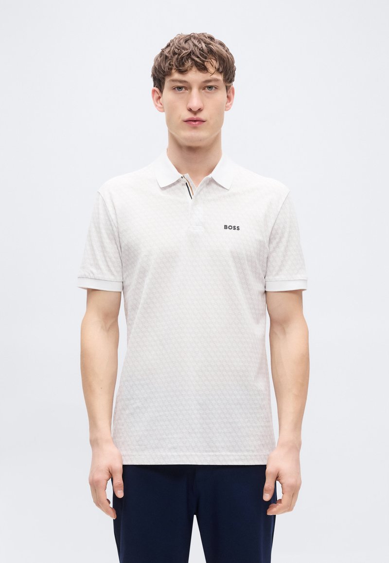 Λευκό πόλο μπλουζάκι με διακριτικό εξαγωνικό μοτίβο, με κούμπωμα δύο κουμπιών, κοντά μανίκια και το λογότυπο "BOSS" στο στήθος.