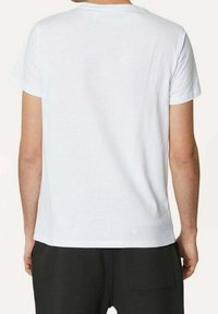 Hvid bomulds t-shirt med rund hals, korte ærmer og lige snit. Ingen synlige mønstre eller brandlogoer på bagsiden.