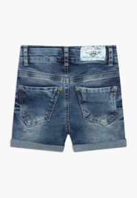 Shorts de mezclilla con un lavado azul desgastado, dos bolsillos traseros con botones metálicos floreados y un dobladillo enrollado. Presenta una etiqueta con un diseño en azul claro.