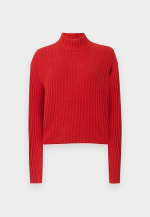 Sarkans ribots džemperis ar augstu kaklu, garām piedurknēm un īsu dizainu. Auduma tekstūra izskatās mīksta un adīta, ar vertikālām svītrām.