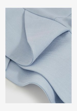 Lyseblåt stof med en tekstureret vævning, der viser bløde folder og glatte kurver, der afslører en subtil glans. Ingen synlige mønstre eller hardware.