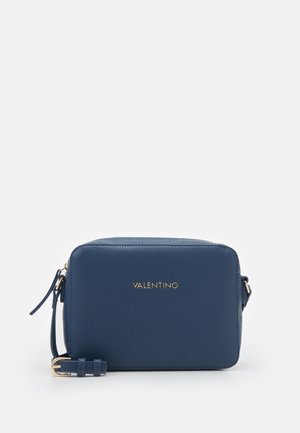 Laivastonsininen teksturoitu nahkainen olkalaukku, jossa kullanvärinen Valentino-logo ja säädettävä hihna, jossa kullanvärinen solki, valkoisella taustalla.