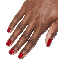 Hand met een mediumbruine huidtoon die kort, glanzende rode nagellak op alle vingers toont. De huid heeft een mooie textuur en natuurlijke lijnen.