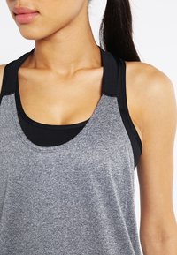 Grå idrottstank topp med svarta accenter, med rundad halsringning och breda remmar. Slät textur, designad för komfort och flexibilitet.