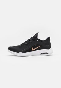Musta urheilukenkä, jossa on verkkomateriaali päällinen, valkoinen pohja ja ruusukultainen Nike-logomerkki. Sisältää nauhat ja näkyvän Air-yksikön kantapäässä.