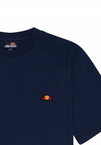 Granatowa bawełniana koszulka z okrągłym dekoltem. Posiada małe, kolorowe haftowane logo na piersi w odcieniach żółtego, pomarańczowego i czerwonego.