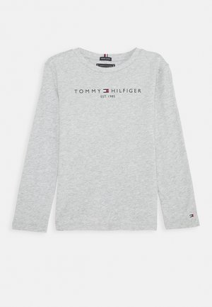 Jasnoszara koszula Tommy Hilfiger z długim rękawem, z logo i napisem "EST. 1985" umieszczonym na środku klatki piersiowej oraz małym logo na lewym rękawie.