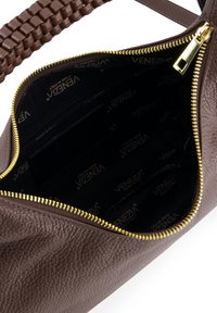 Braune Lederhandtasche mit strukturierter Oberfläche, goldfarbener Reißverschluss und Textilfutter mit wiederholtem Branding. Das Innere umfasst Reißverschluss- und Steckfächer.