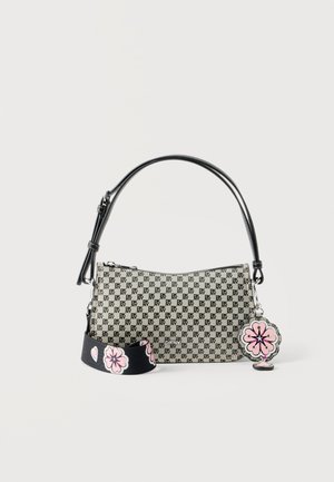 Liten rektangulær beige håndveske med gjentatt svart "DKNY"-logo, sort håndtak, avtagbar svart stropp med rosa blomstermønster og rosa blomsteranheng.