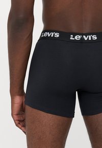 Boxer briefs in cotone nero con un ampio cinturino elastico caratterizzato dal logo bianco "Levi's". Texture liscia e design aderente.