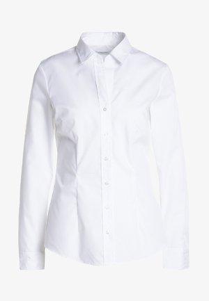 Hvid skjorte med lange ærmer, spidse kraver og et tætsiddende design. Fremstillet af glat stof med en subtil glans. Har en knaplukning.