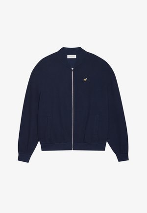 Tamsiai mėlynas zip-up džemperis su tekstūruotu trikotažu, banguotomis apykaklėmis ir apatine dalimi, dviem priekinėmis kišenėmis ir maža auksine logotipu ant krūtinės.
