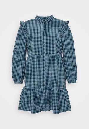 Vestido xadrez azul e preto com mangas longas, ombros com babados, fecho de botão e uma bainha em camadas e ligeiramente ampla.