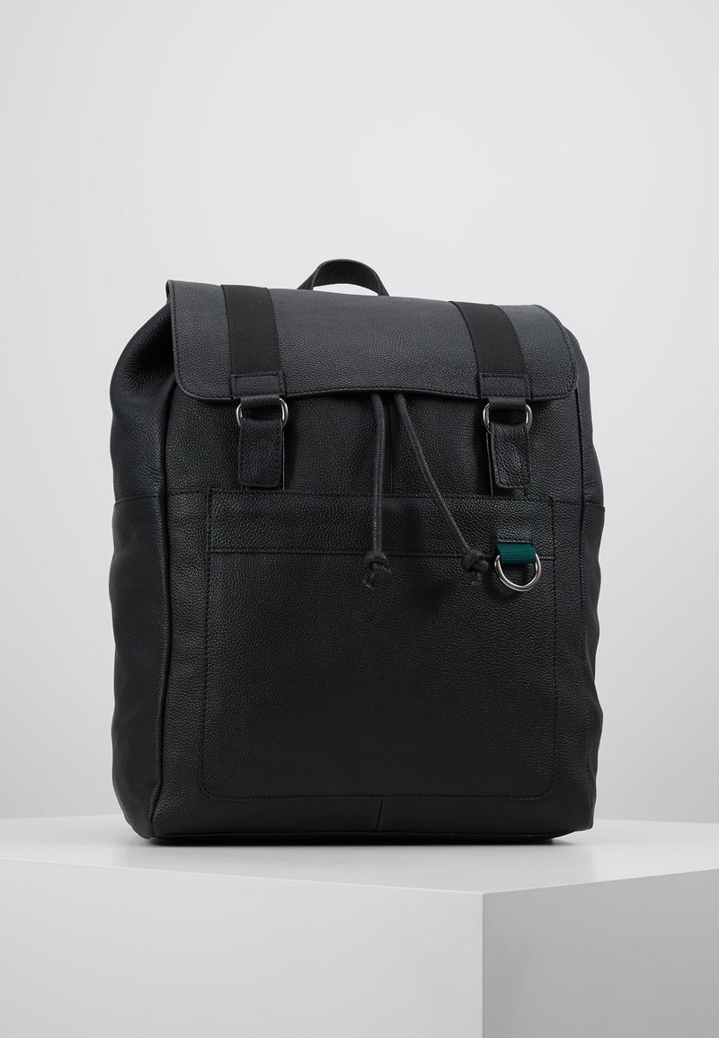 Svart läderryggsäck med en strukturerad yta, utrustad med ett topplock, två remmar och en framficka med dragsko.