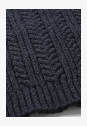 Dunkelblauer Strickstoff mit einem strukturierten Muster, das erhabene Zickzack- und Rippenakzente aufweist, die Tiefe und visuelles Interesse schaffen.