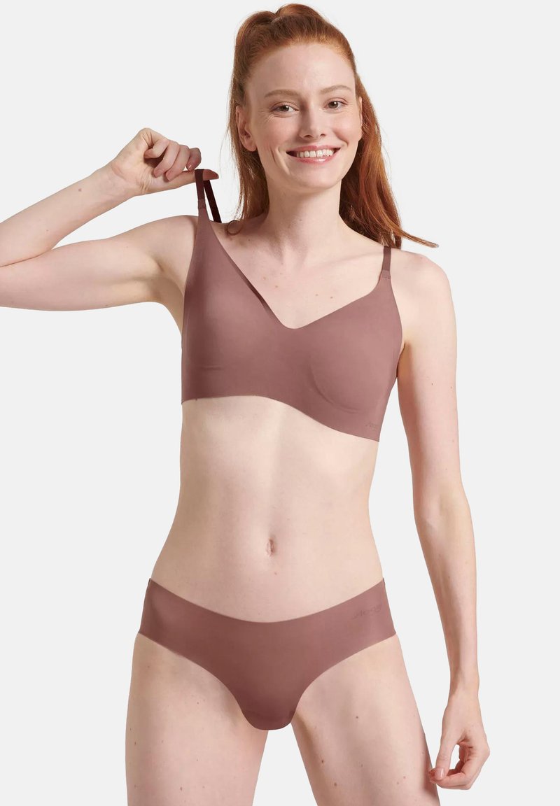 Reggiseno seamless mauve e bikini abbinati, materiale morbido, spalline sottili, design a V, texture liscia senza cuciture visibili o accessori.