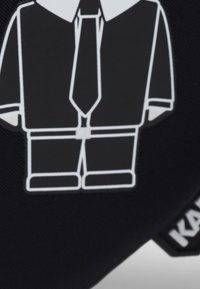 Czarna tkanina z grafiką garnituru z krawatem w białym konturze. Projekt przedstawia koszulę i spodnie, podkreślając czyste linie i kształty.