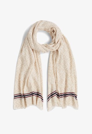 Beige sjaal met een geometrisch patroon, zachte textuur en contrasterende gestreepte randen in marineblauw en rood. Gedrapeerde lusvorm.