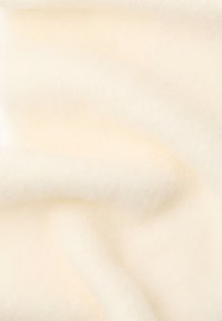 Tela de lana blanca suave con una textura esponjosa, que presenta una superficie lisa y variaciones sutiles en el tono. Sin patrones ni adornos visibles.