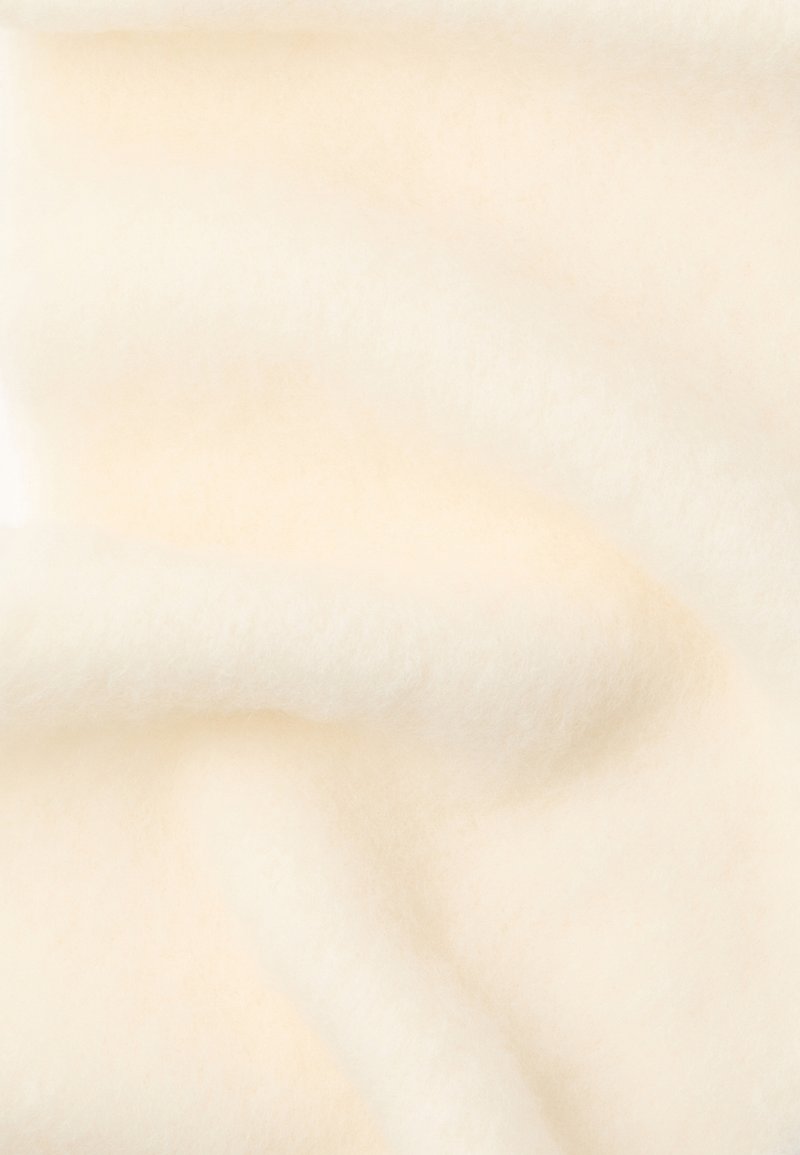 Soft white wool fabric with a fluffy texture, featuring a smooth surface and subtle variations in shade. No visible patterns or accents.