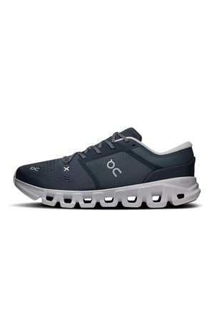 Baskets de sport bleu foncé avec semelle blanche épaisse comportant plusieurs découpes, logo blanc sur le côté et lacets bleu foncé.