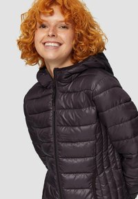 Veste matelassée à capuche en violet foncé avec texture matelassée, fermeture éclair complète et design ajusté. Dotée d'une finition en tissu doux et lisse.