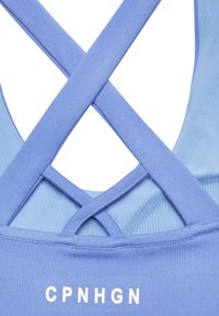 Hellblaues Sporttanktop mit einer Rückendesign im Kreuzstil, solider Textur und aufgedrucktem weißen Logo "CPNHGN" am Saum.