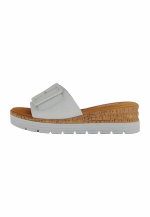 Hvid slidesandal med en bred rem og justerbar spænde, kork-mellemsål og hvid gummi outsole. Glat tekstur med syede detaljer.
