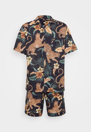 Short-sleeve shirt and shorts set in dark fabric featuring a leopard and floral print, with green leaves and beige flowers.