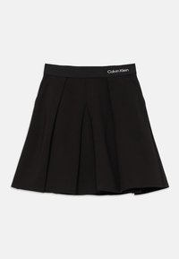 Čierna plisovaná sukňa s elastickým pásom, na pravej strane so značkou Calvin Klein v bielej farbe.