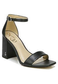 Zwarte leren sandalen met hak, voorzien van een brede teband en een enkelband. Heeft een vierkante teen en een vierkante blokhak met gegraveerde details.