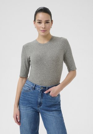 Haut gris ajusté à manches courtes en matière côtelée, associé à un jean en denim bleu taille haute avec bouton de fermeture et poches avant.