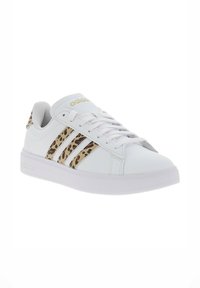 Zapatilla blanca con acentos de estampado de leopardo, con tres franjas laterales y una suela de goma texturizada. Detalle del logotipo dorado en la lengua.