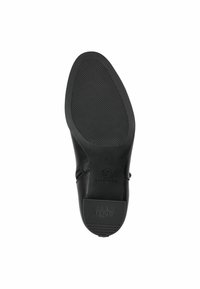 Black shoe sole with a textured grip pattern, featuring a subtle heel and branding. Smooth material extends to the sides with minimal accents.