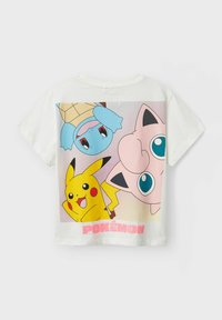 Hvit bomull t-skjorte med et fargerikt grafisk design av Pikachu, Squirtle og Jigglypuff, med "POKÉMON" trykt i rosa nederst.