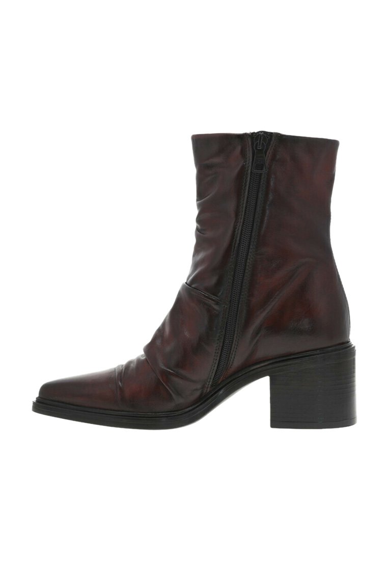 Bottine en cuir marron avec un nez pointu, fermeture zippée et un talon bloc empilé. Présente une texture froncée sur le dessus.