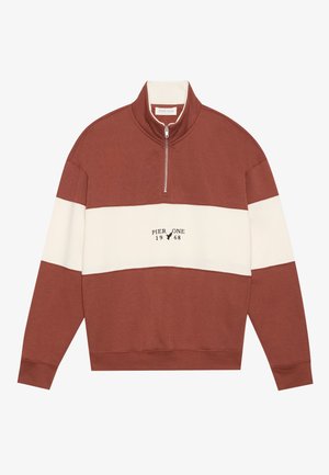 Pulovr v barvách červené a krémové s blokovým designem, featuring vysoký límec a čtvrtzip. Text "PIER ONE 1968" je tištěn uprostřed na přední straně.
