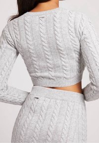 Grauer, kurz geschnittener Pullover mit Zopfmuster, langen Ärmeln und geripptem Saum, mit strukturiertem Design und kleinem Markenakzent.
