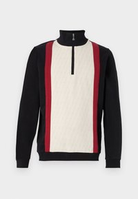 Schwarzer und cremefarbener Pullover-Sweatshirt mit einem Halb-Reißverschluss-Kragen. Verfügt über rote Seitenstreifen und ein strukturiertes geometrisches Muster im cremefarbenen Bereich.