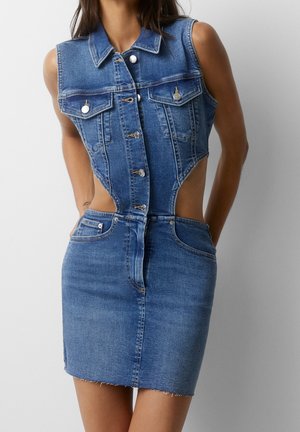 Niebieska, dżinsowa sukienka bez rękawów z zapinanym na guziki przodem, wycięciami po bokach, przednimi kieszeniami na piersi oraz dopasowaną spódnicą z nieobrobionym wykończeniem.