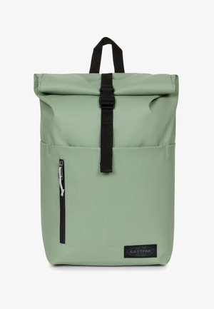 Mochila verde tipo roll-top con herrajes negros, bolsillo lateral con cremallera, correas ajustables y un prominente parche del logo de Eastpak en la parte frontal.