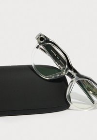 Clear acrylic eyeglasses with a modern angular design partially resting on a black case. The lenses are transparent with a slight tint.