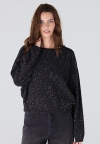 Zwarte cropped sweater met een textuurafwerking, met zilveren sprankels door het geheel, brede mouwen en een ronde halslijn.