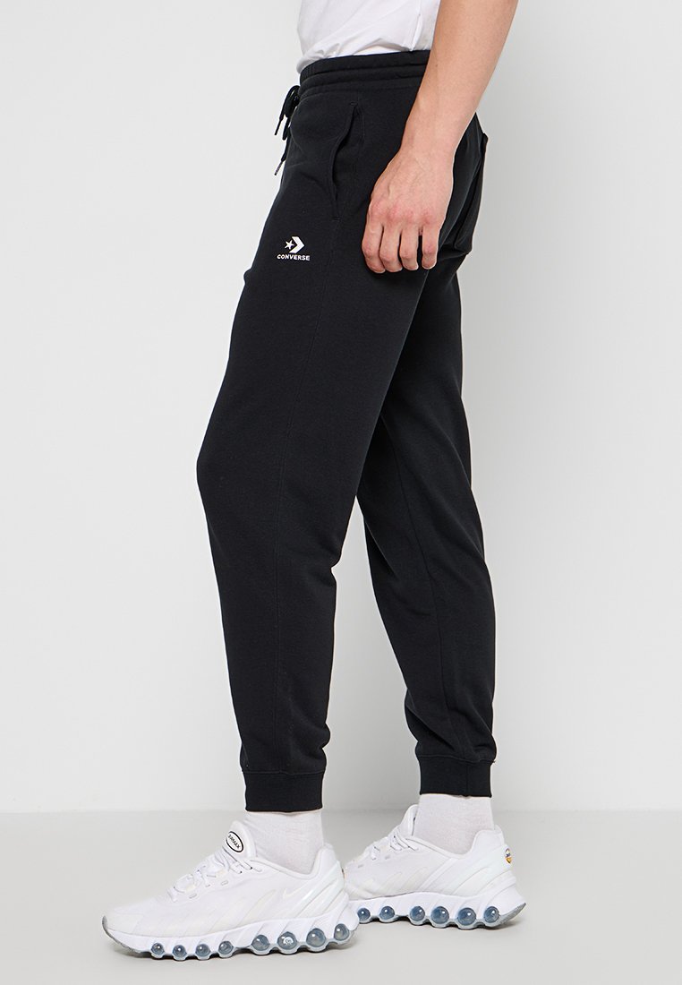 Pantaloni jogger neri realizzati in tessuto morbido, con vita elasticizzata e coulisse, polsini alle caviglie e un piccolo logo bianco sulla coscia.