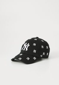 Zwarte baseballpet versierd met witte geborduurde New York Yankees-logo's, met een klassiek gebogen randontwerp.